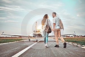 Young couple walking on runway. People carring backpacks