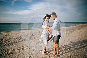 Young couple walking on the sea beach. Summer vacation on the island