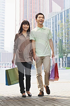 Young couple walking with shopping bags in hands, Beijing, China