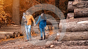 A young couple walks in the woods with a little boy