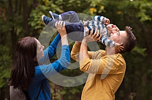 A young couple walks in the woods with a little boy