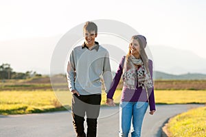 Young couple wandering in sunny countryside.