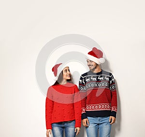 Young couple in warm sweaters and Christmas hats