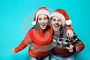 Young couple in warm sweaters and Christmas hats