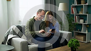 A young couple watching a fun video on a smartphone in their cozy living room