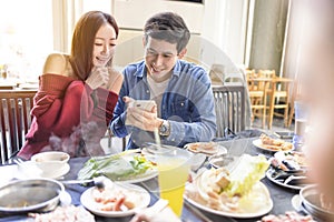 Young couple watching the mobile phone in the  restaurant