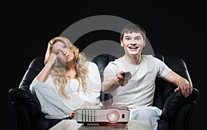 Young couple watching a movie while sitting on a sofa
