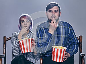 A Young couple watching movie. They are worried