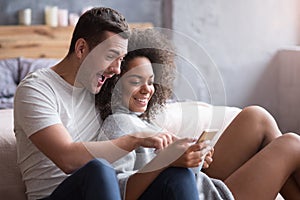 Young couple watching photos from their honeymoon