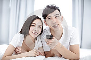 Young Couple Watching Television and  Relaxing In bed