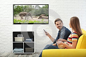 Young couple watching TV on sofa