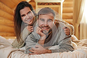 Young couple wearing warm sweaters on bed at home