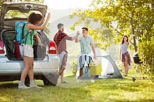 Young couple welcomed their friends join them on a camping trip