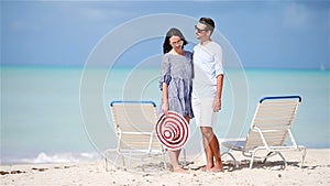 Young couple on white beach during summer vacation. Happy family enjoy their honeymoon