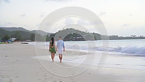 Young couple on white beach during summer vacation. Happy family enjoy their honeymoon