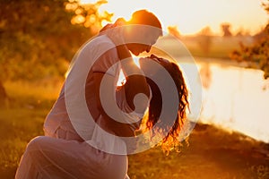 Young couple in white dancing on the background of sunset