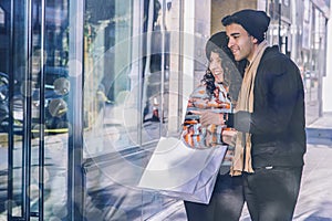 Young Couple window shops in the city - Christmas Shopping - Shopping Bags
