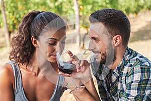 young couple of winemakers tasting red wine from a glass tumbler sitting