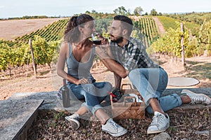 young couple of winemakers tasting red wine from a glass tumbler sitting