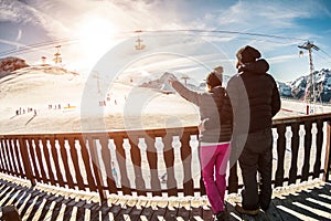 Young couple in winter vacation at snow resort mountain - Skiers tourists relaxing in ski slope chalet - Travel, holiday,