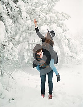 Young couple in winterwear enjoying snowfall. Love story