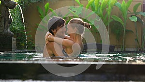 Young couple woman and man have fun in their private swimming pool. Honeymoon concept