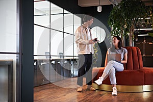 Young couple in work space for start up business have meeting in seating area of open plan office