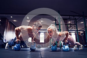 Young couple is working out at gym. Attractive woman and handsom