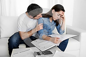 Young couple worried home in stress husband comforting wife in financial problems