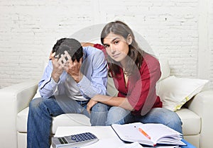 Young couple worried home in stress wife comforting husband accounting debt unpaid bills bank papers expenses