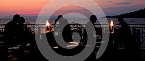 Young couples at restaurant having dinner. Silhouette photo