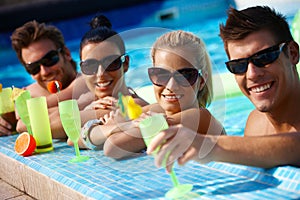 Young couples in swimming pool with cocktail