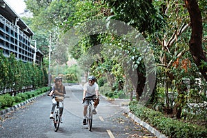 Young couples wearing helmets enjoy riding bikes together