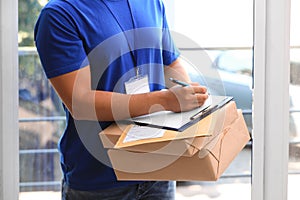 Young courier delivering parcels on doorstep