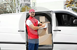 Young courier holding clipboard and parcel