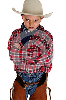 Young cowboy glaring at camera wearing hat and cha