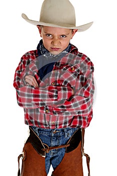 Young cowboy glaring at camera wearing hat and cha photo
