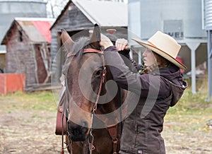 Young cowgirl getting ready for a horse ride