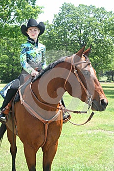 Young cowgirl sitting on a quarterhorse