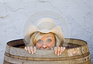 Young cowgirl smiling from inside a barrel