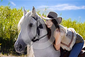 Young cowgirl on white horse smile