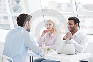 Young coworkers having brainstorming session in modern office