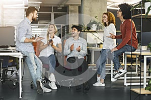 Young coworkers having pleasant talk in office