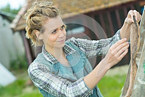 Young craftswoman hanging somthing outside