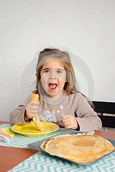 Young crazy girl eating a stack of pancakes.