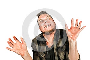 Young crazy guy scares like a devil with hands up isolated on background