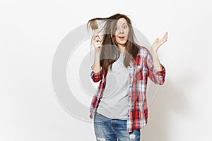 Young crazy loony woman in casual clothes painting hair with paint brush isolated on white background. Instruments photo