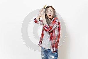 Young crazy loony woman in casual clothes winding hair on paint brush isolated on white background. Instruments