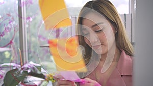 Young Creative businesswoman holding a marker and writing plan and share idea on glass wall with sticky note, Brainstorming and