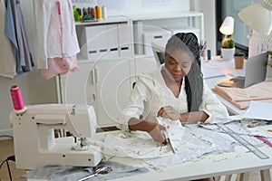 young creative female designer or stylist designers working in atelier and sewing new clothes